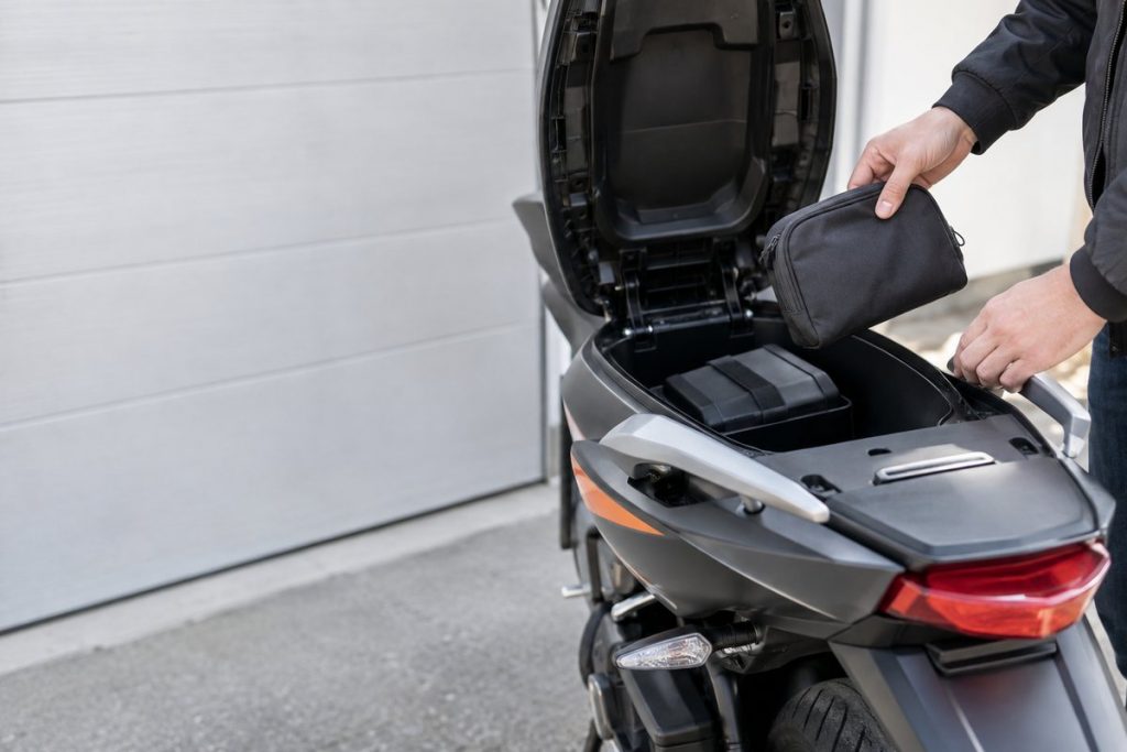 バイクの収納部分から私物を取り出す手元