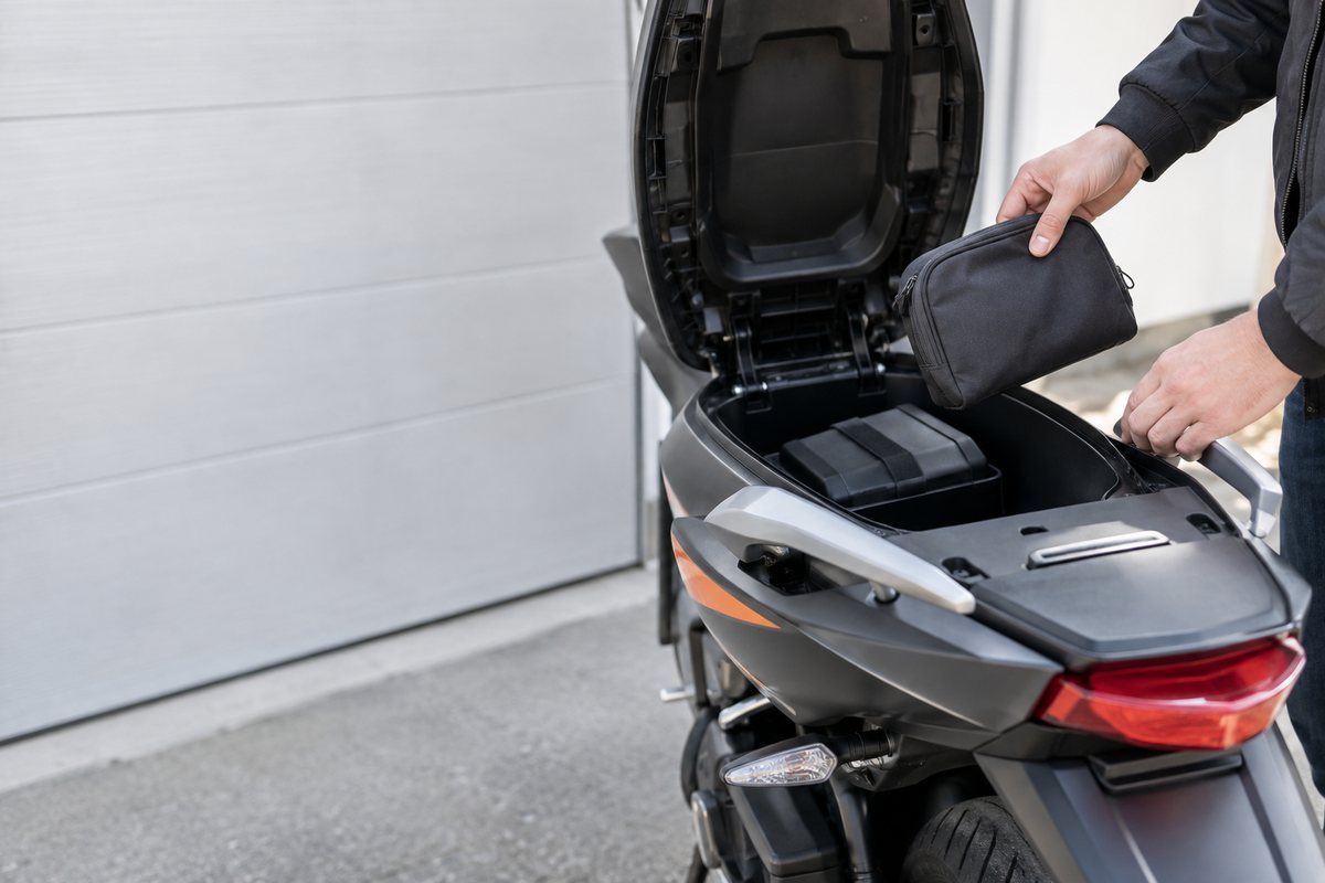 バイクの収納部分から私物を取り出す手元